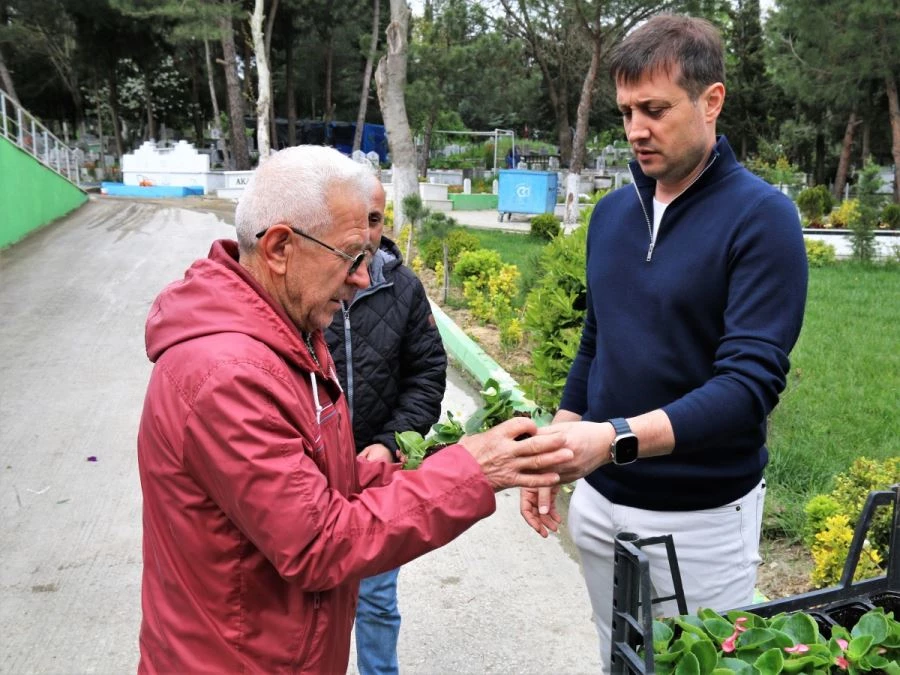 KABİR ZİYARETİNE GELENLERE ÇİÇEK DAĞITIMI YAPILDI